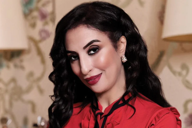 Editorial portrait of Salwa Idrissi Akhannouch in a red blouse.