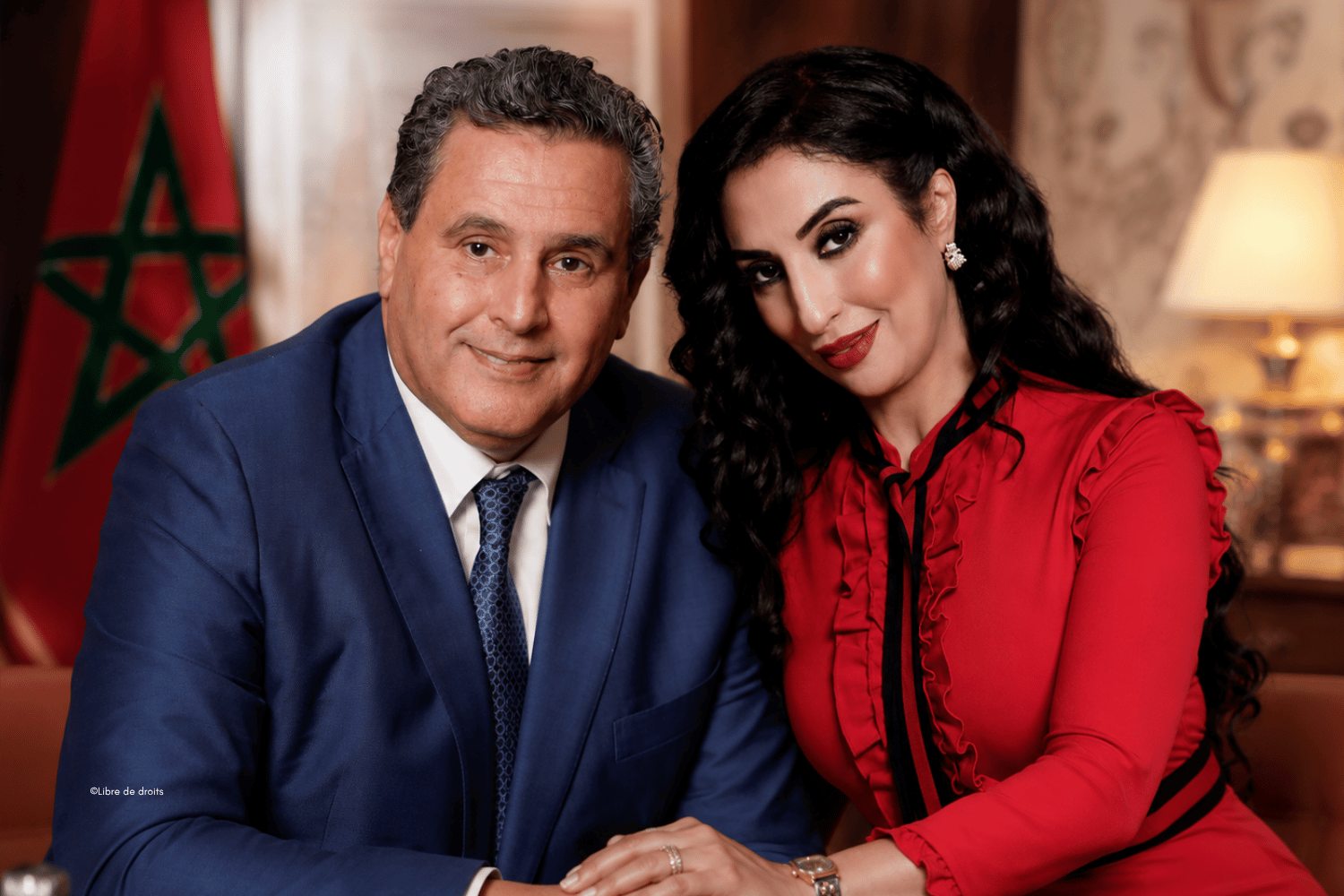 Salwa Idrissi Akhannouch photographed with Aziz Akhannouch, with the Moroccan flag behind them.